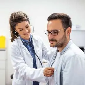 Doctor using stethoscope on patient.